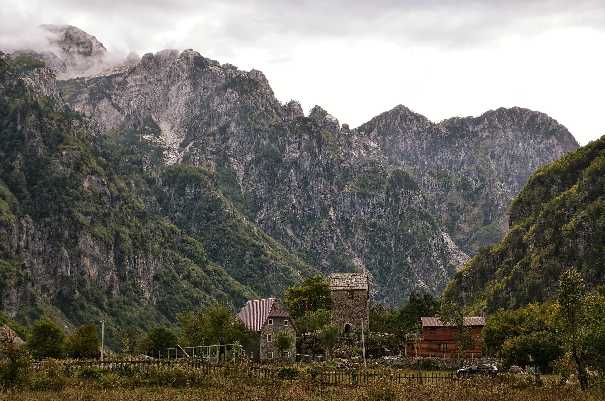 The stone lock-in tower of Theth beneath the peaks of the Albanian Alps